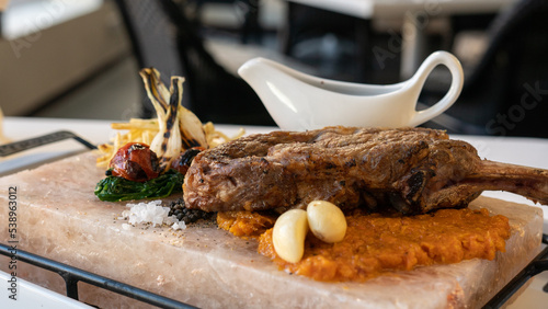 Tableau sur toile Delicious steak on the salt stone with grilled vegetables, potato and sous