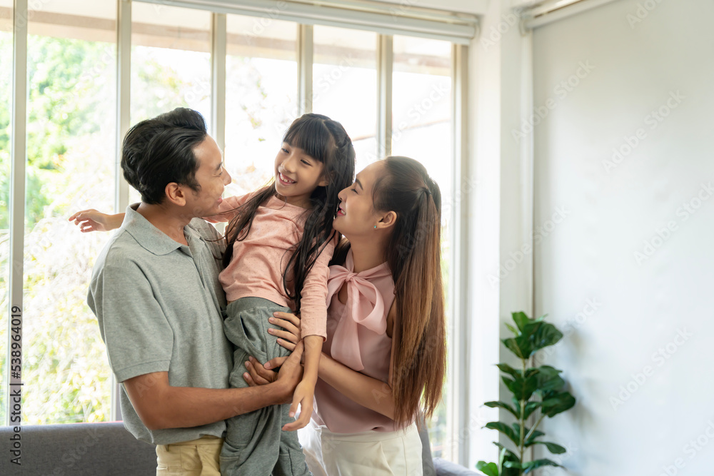 Asian family photo There are fathers, mothers and daughters. The father is the one holding the daughter. and having fun at home on the weekend Asian family photo There are fathers, mothers and daughters. The father is the one holding the daughter. and having fun at home on the weekend