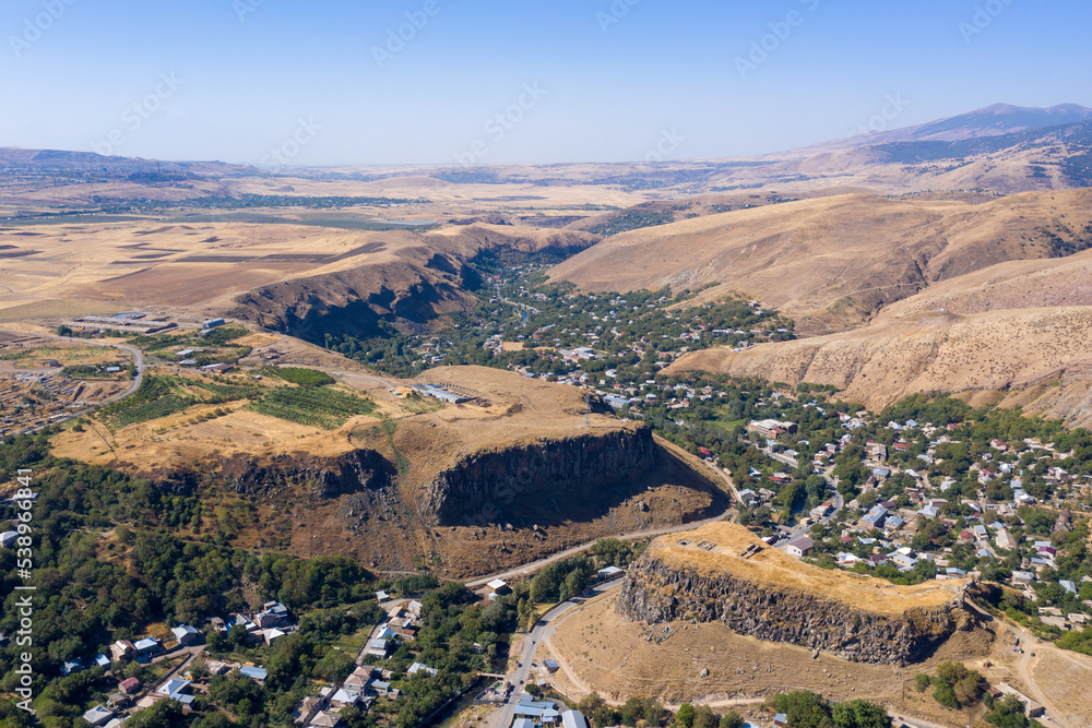 Drone view of Hrazdan river valley, surrounding plateau and Bjni village on sunny day. Kotayk Province, Armenia.