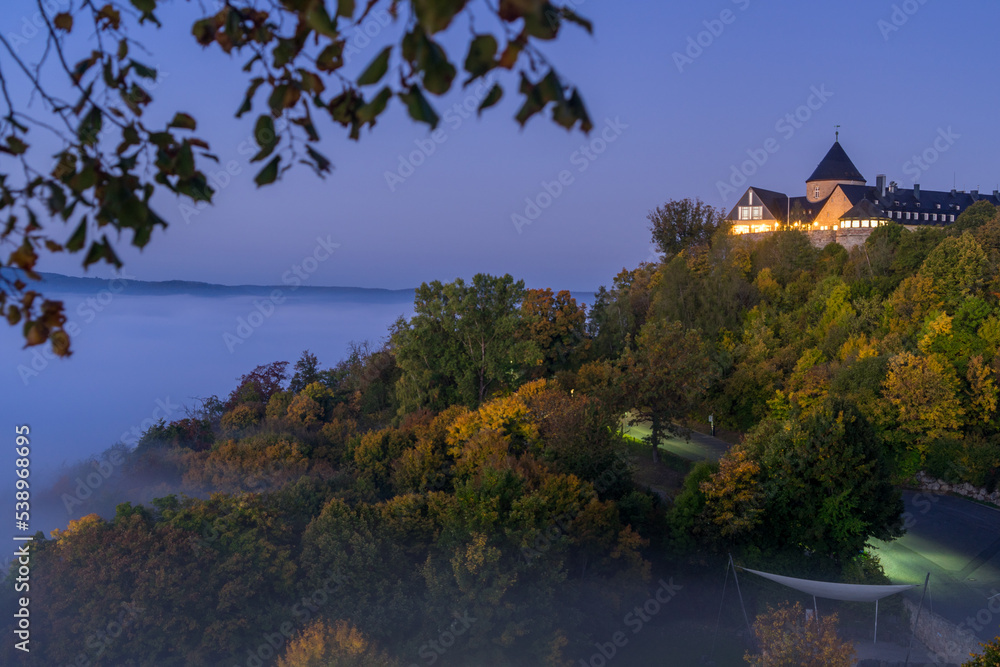 View to german palais called Waldeck in the morning with fog over the lake Edersee