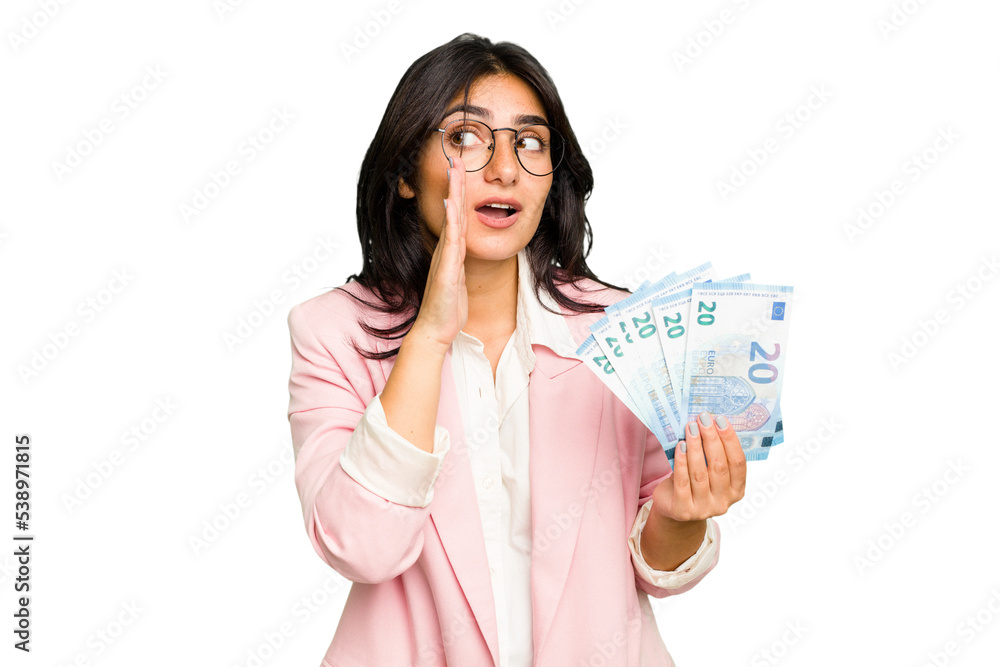 Young business Indian woman holding banknotes isolated is saying a secret hot braking news and looking aside Young business Indian woman holding banknotes isolated is saying a secret hot braking news and looking aside