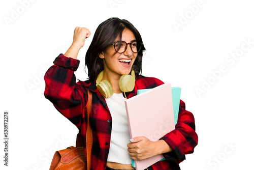 Young student Indian woman wearing headphones isolated raising fist after a victory, winner concept.
