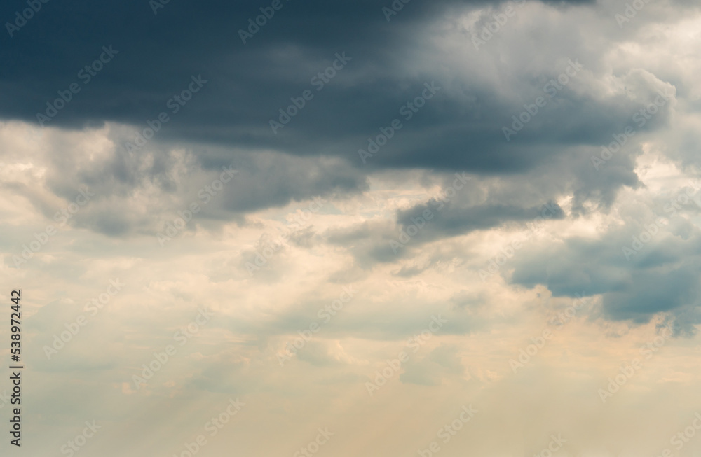 Dramatic Sky Background with sunny beams. Panoramic view of Stormy Clouds in Dark sky