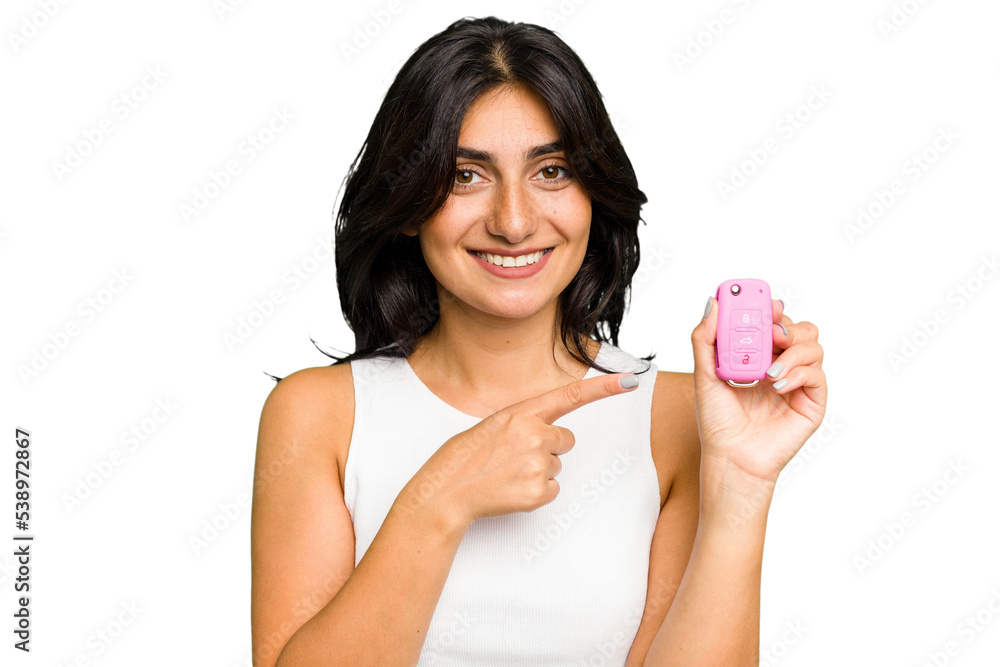 Young Indian woman holding a car keys isolated smiling and pointing aside, showing something at blank space. Young Indian woman holding a car keys isolated smiling and pointing aside, showing something at blank space.