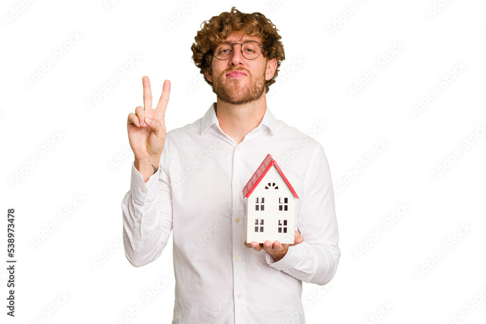 Business caucasian man holding toy house isolated on white background showing number two with fingers. Business caucasian man holding toy house isolated on white background showing number two with fingers.
