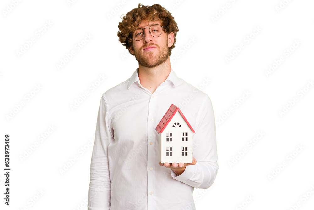 Business caucasian man holding toy house isolated on white background happy, smiling and cheerful. Business caucasian man holding toy house isolated on white background happy, smiling and cheerful.