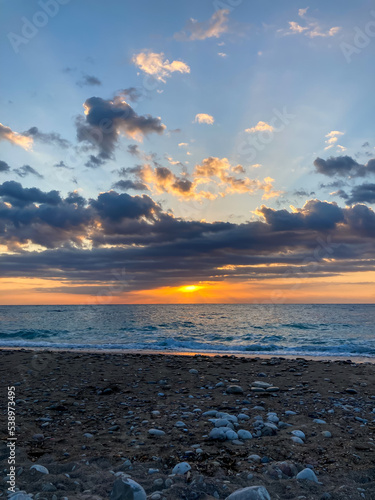 Sunrise landscape with clouds and sea. View of the sun rising above the sea. Selective focus.