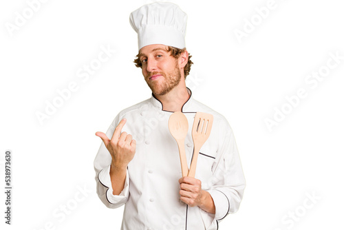 Canvas Print Young cook man isolated on white background pointing with finger at you as if inviting come closer