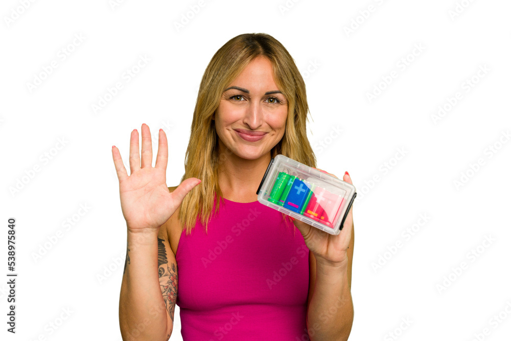 Young caucasian woman holding battery box isolated on green chroma background smiling cheerful showing number five with fingers. Young caucasian woman holding battery box isolated on green chroma background smiling cheerful showing number five with fingers.