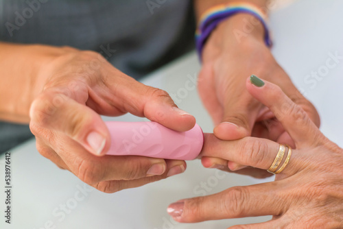 Close-up of an adult woman's hands doing nail impressions. Hands of a beautician giving a manicure to a client in her workspace in natural daylight.