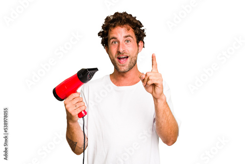 Young caucasian man holding an hairdryer isolated having an idea, inspiration concept.