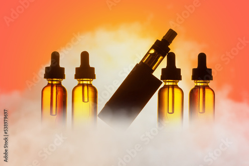Vape pen in puffs of smoke. Vaper kit on colorful background. Vape pen close up. Vaper device with liquid for refilling. Vape pen sale concept. Technology without tobacco electronic cigarettes