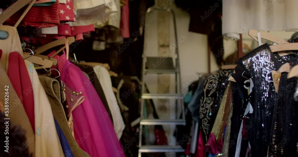 The movement of the camera through the rows of clothes in the store. Wooden hangers hold the items on the metal tube. Metallic staircase. The movement of the camera through the rows of clothes in the store. Wooden hangers hold the items on the metal tube. Metallic staircase.