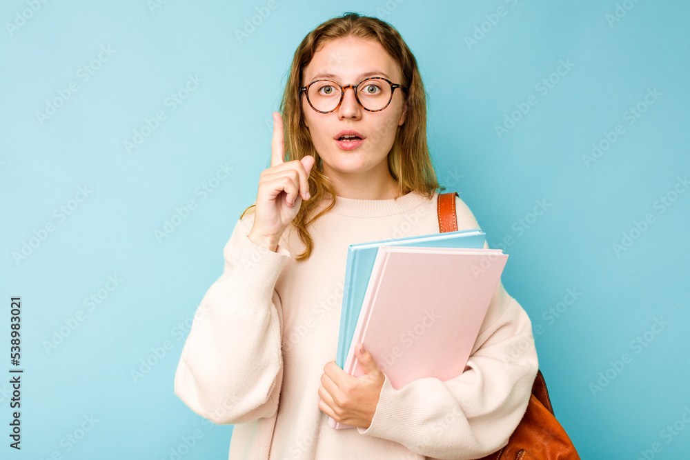 Young student caucasian woman isolated on blue background having some great idea, concept of creativity. Young student caucasian woman isolated on blue background having some great idea, concept of creativity.