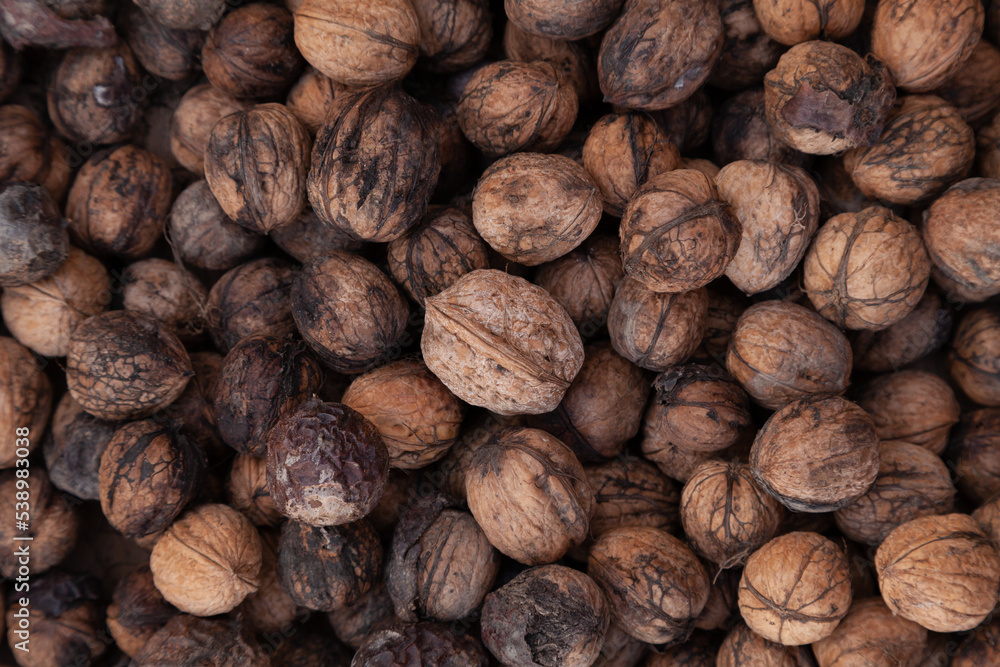 Walnuts background texture, unshelled and unprocessed healthy food, in warm autumnal tones Walnuts background texture, unshelled and unprocessed healthy food, in warm autumnal tones