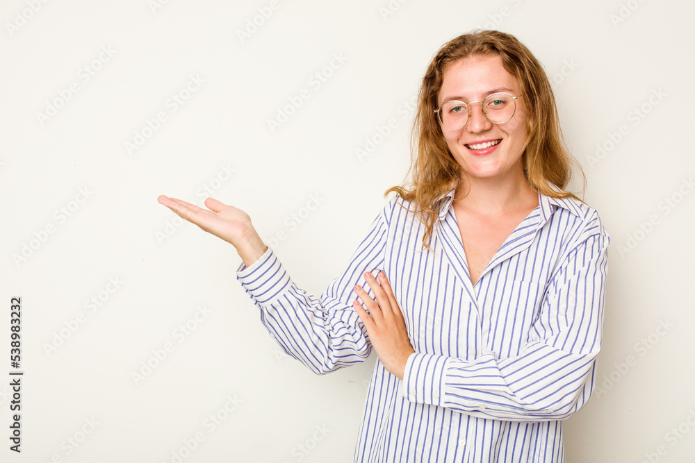 Young caucasian woman isolated on white background showing a copy space on a palm and holding another hand on waist. Young caucasian woman isolated on white background showing a copy space on a palm and holding another hand on waist.