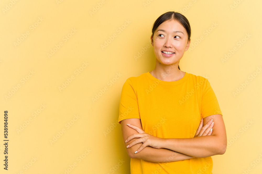 Obraz premium Young Asian woman isolated on yellow background smiling confident with crossed arms.