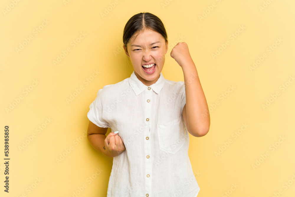 Young Asian woman isolated on yellow background cheering carefree and excited. Victory concept. Young Asian woman isolated on yellow background cheering carefree and excited. Victory concept.