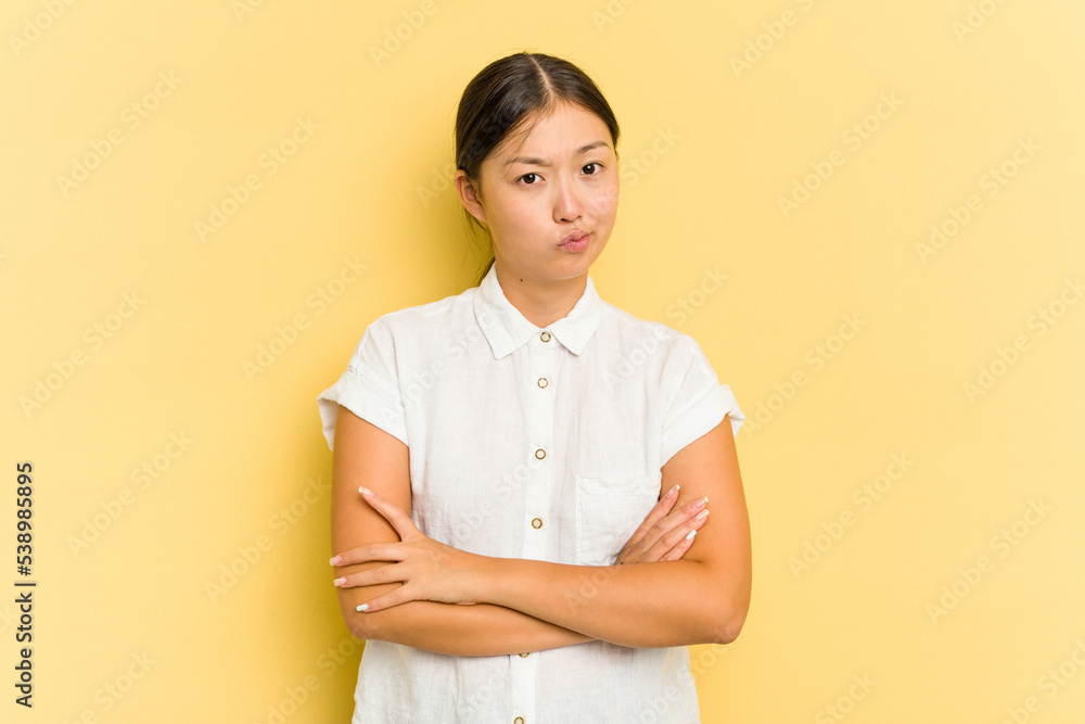 Young Asian woman isolated on yellow background unhappy looking in camera with sarcastic expression. Young Asian woman isolated on yellow background unhappy looking in camera with sarcastic expression.