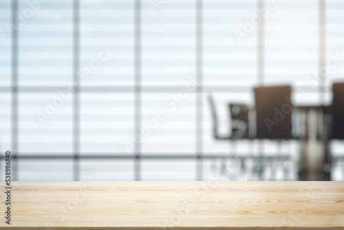 Empty wooden office table with light sunny furnished conference room with large window on background, mockup © Pixels Hunter