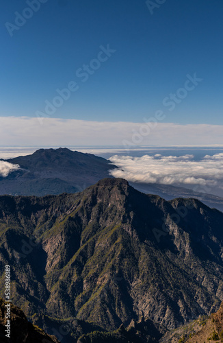 Aerial view of savage landscape with low clouds cover the forest and mountains © Nestor