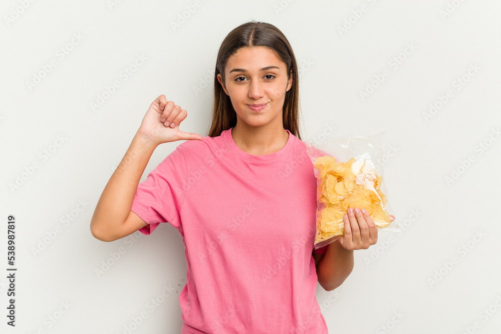 Young Indian woman holding crips isolated on white background feels proud and self confident, example to follow. Young Indian woman holding crips isolated on white background feels proud and self confident, example to follow.