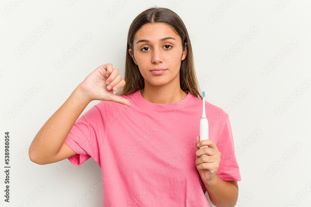Young Indian woman brushing teeth isolated on white background showing a dislike gesture, thumbs down. Disagreement concept. Young Indian woman brushing teeth isolated on white background showing a dislike gesture, thumbs down. Disagreement concept.
