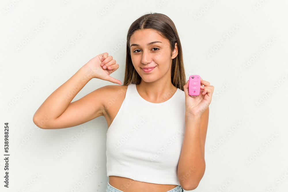 Young indian woman holding an electronic pink car keys feels proud and self confident, example to follow. Young indian woman holding an electronic pink car keys feels proud and self confident, example to follow.