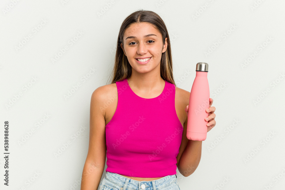 Young indian woman holding a pink thermo isolated on white background happy, smiling and cheerful. Young indian woman holding a pink thermo isolated on white background happy, smiling and cheerful.