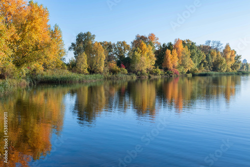 Autumn landscape of colorful trees and a river.