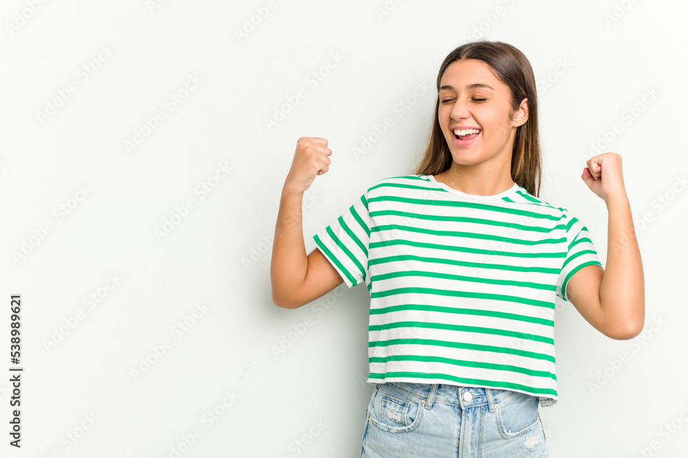 Young Indian woman isolated on white background raising fist after a victory, winner concept. Young Indian woman isolated on white background raising fist after a victory, winner concept.