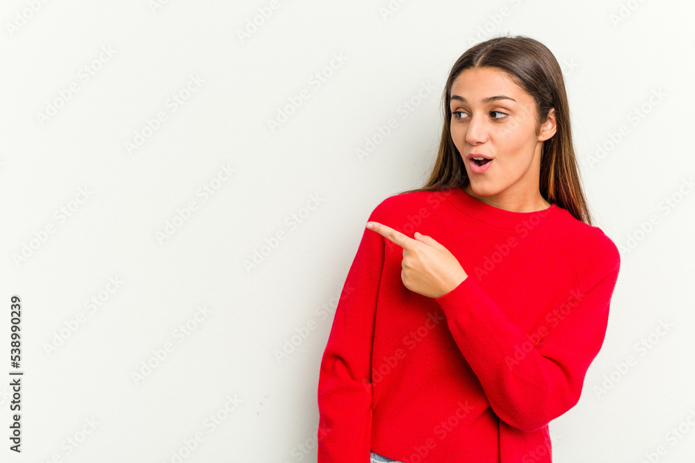 Young Indian woman isolated on white background points with thumb finger away, laughing and carefree. Young Indian woman isolated on white background points with thumb finger away, laughing and carefree.