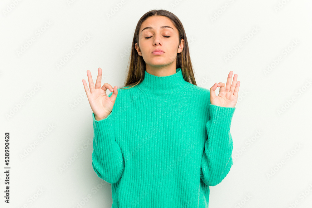 Young Indian woman isolated on white background relaxes after hard working day, she is performing yoga. Young Indian woman isolated on white background relaxes after hard working day, she is performing yoga.