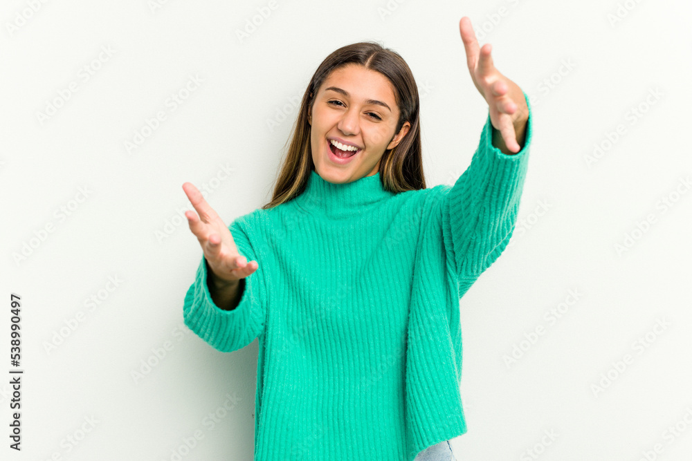 Young Indian woman isolated on white background feels confident giving a hug to the camera.