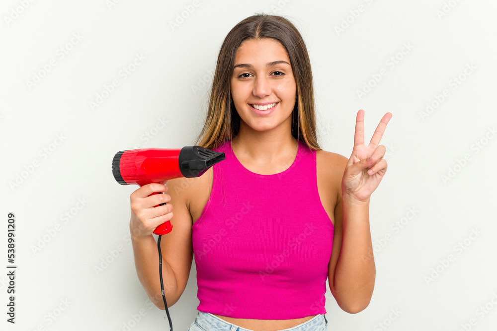 Young Indian woman holding a hairdryer isolated on white background Young Indian woman holding a hairdryer isolated on white background