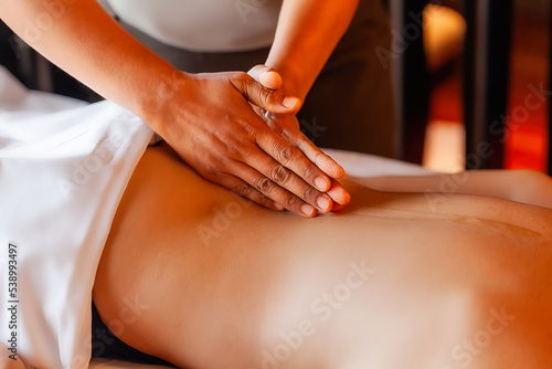 Woman gets body massage in spa salon, female person on massage therapy