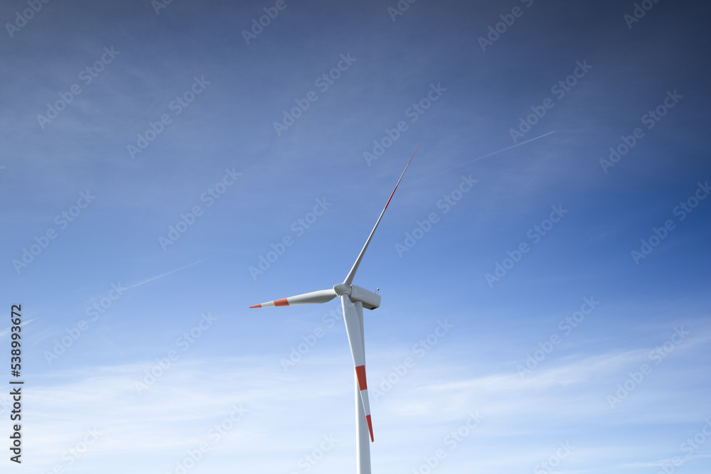 A wind farm or wind park at sunset located in the mountains with snow of Italy Europe and it allows to realize clean energy. It’s sustainable, renewable energy for enviromental