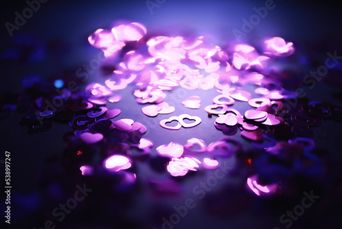 Love background. Red beads in the shape of a heart on a glitter and bokeh background.