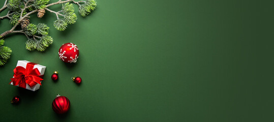 Merry Christmas and Happy Holidays greeting card, frame, banner. New Year. Noel. Christmas ornaments and gift on green background top view. Winter xmas holiday theme. Flat lay	
