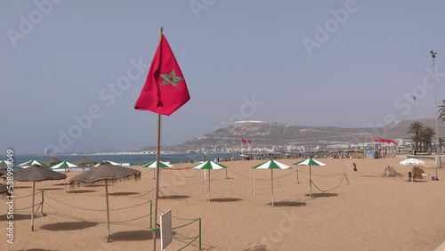 Moroccan flag waving with people running in the background photo