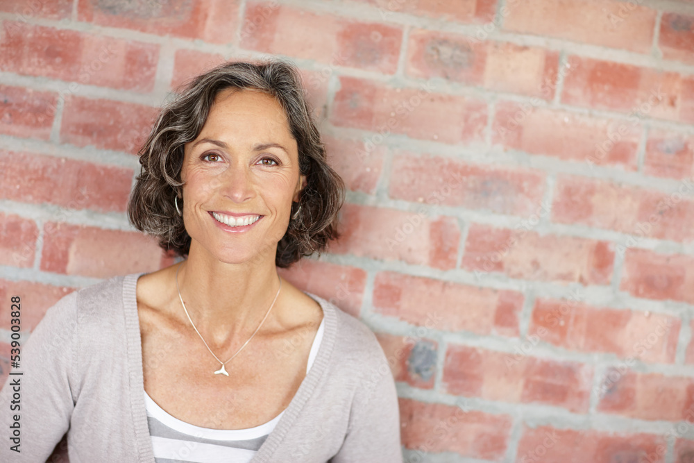 Geting some fresh air. A mature woman leaning against a facebrick wall. Geting some fresh air. A mature woman leaning against a facebrick wall.