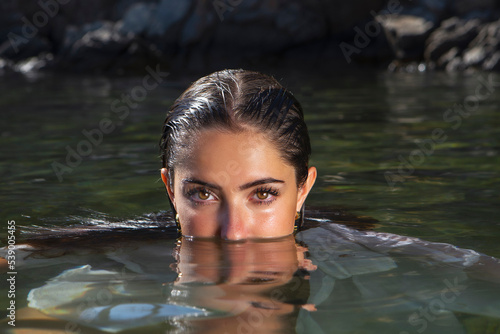 Sensual wet woman in clear lake water photo