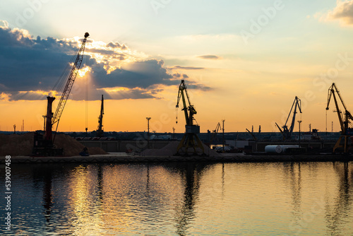 Port cranes on the territory of the seaport in Constanta, Romania, at sunset. Seaport area with cranes.