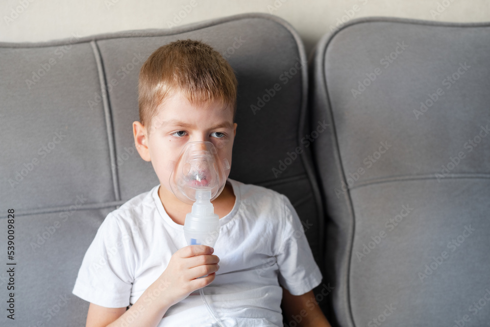 A little boy sits with an inhalation mask during cough and bronchitis A little boy sits with an inhalation mask during cough and bronchitis