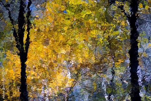 Pocono Mountains, Pennsylvania: The reflections of trees and autumn leaves in a stream create impressionist patterns and textures.