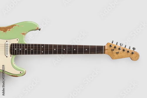 Old green guitar on white background. Vintage music wallpaper