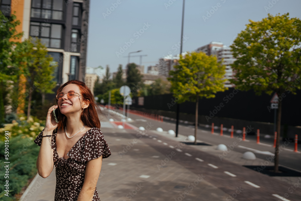 Cute girl talking on mobile phone on modern city background Cute girl talking on mobile phone on modern city background