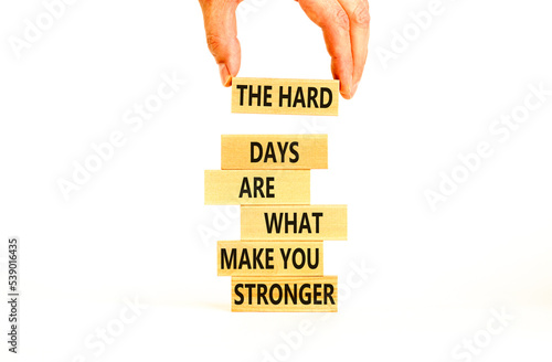 Support and be stronger symbol. Concept words The hard days are what make you stronger on wooden blocks. Bussinesman hand. Beautiful white background. Business and be stronger concept. Copy space.