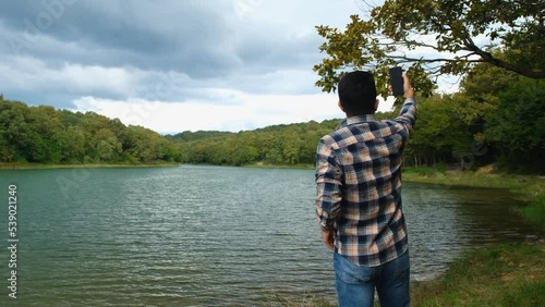 Bearded man trying to find a signal in forest, using mobile phone in nature, no signal concept, lost in forest, young guy looking for a signal, 