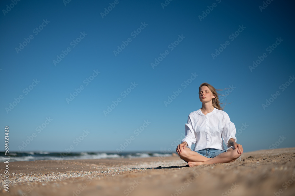 Girl practice meditation on the beach. With space for text or design Girl practice meditation on the beach. With space for text or design